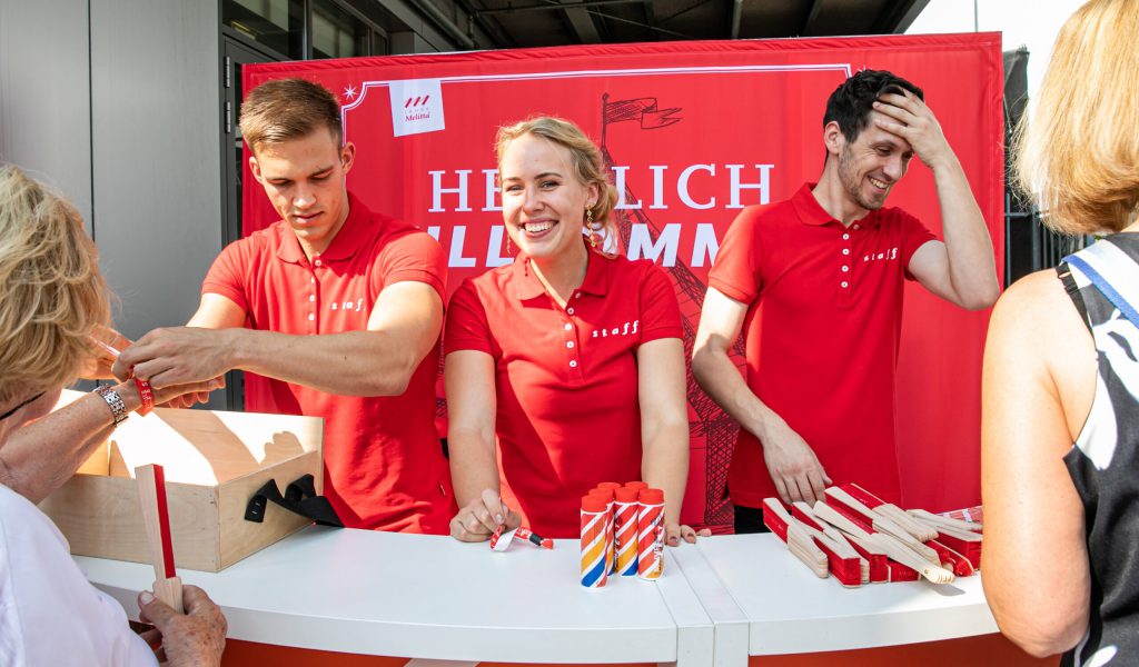 Melitta Sommerfest: Junge Leute am Empfang mit Give Aways und Corporate T-Shirts